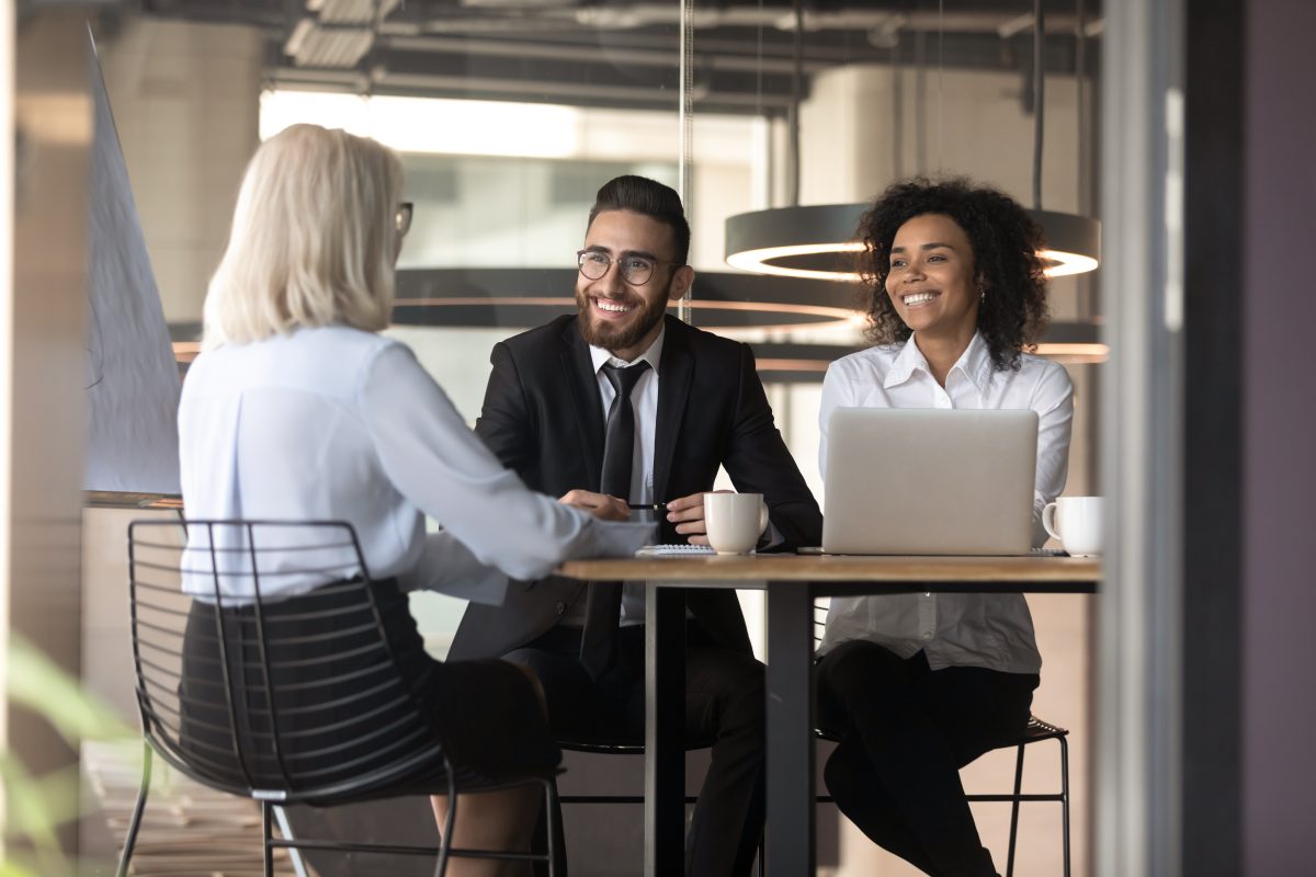 Smiling multiracial employers laugh talking with job candidate in office