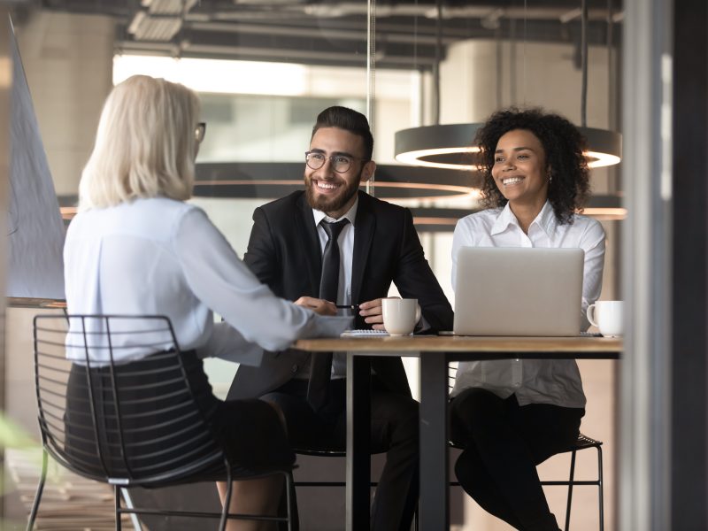 Smiling multiracial employers laugh talking with job candidate in office