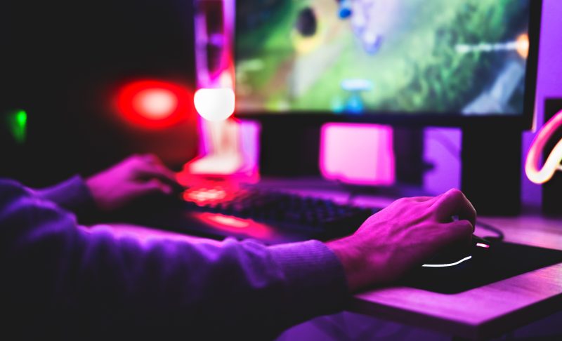 Young gamer playing online video games while streaming on social