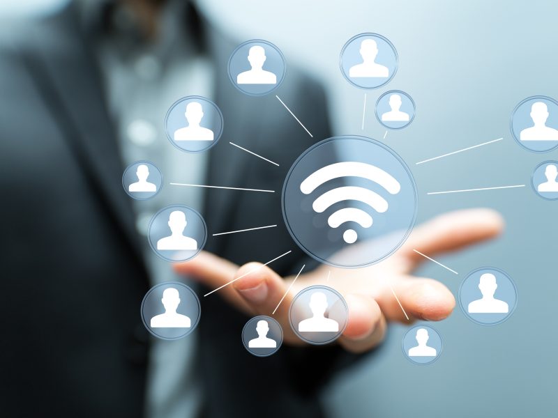 wireless network Businessman holding 3D rendering group of blue people